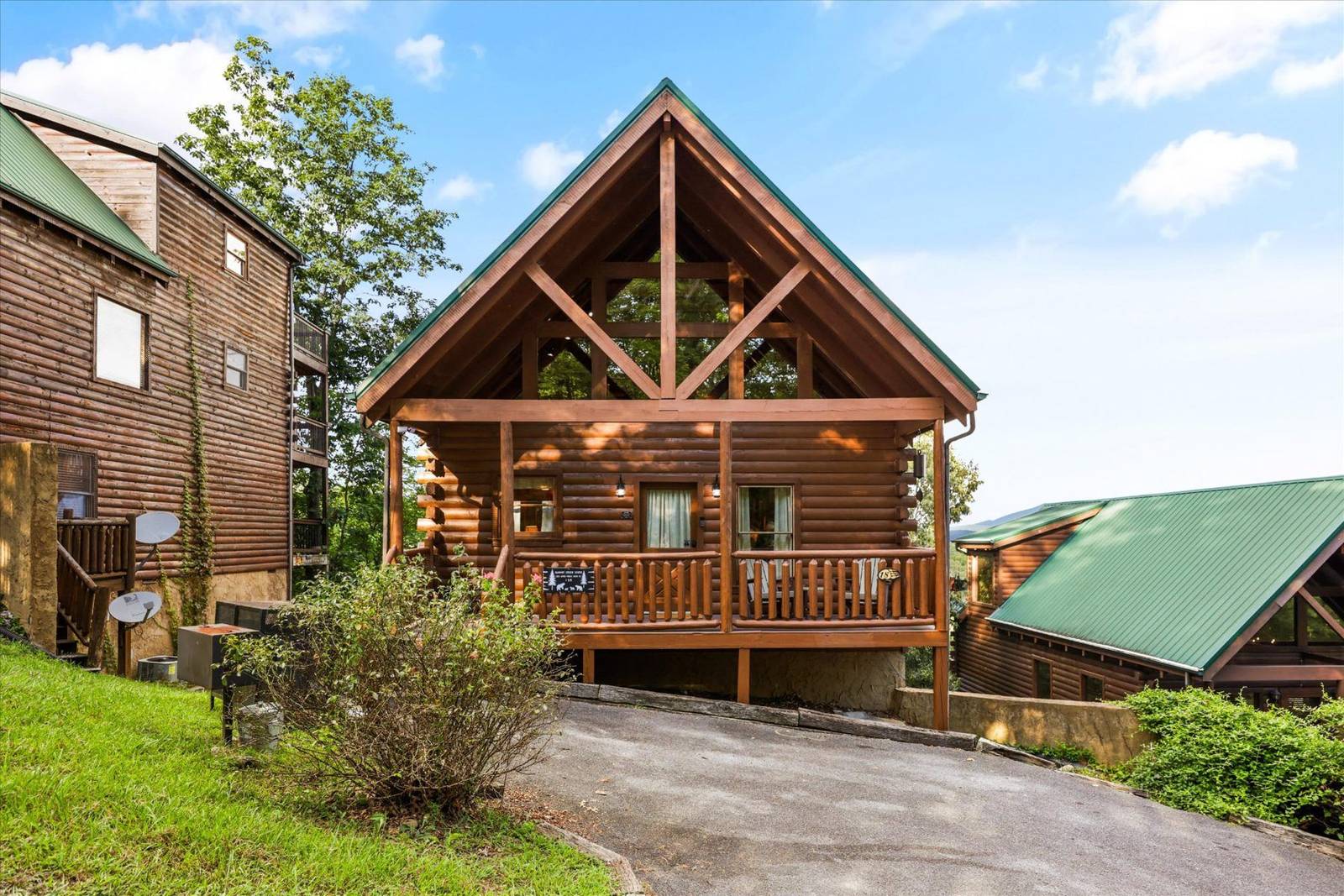 Log cabin with A-frame and porch, beside another cabin
