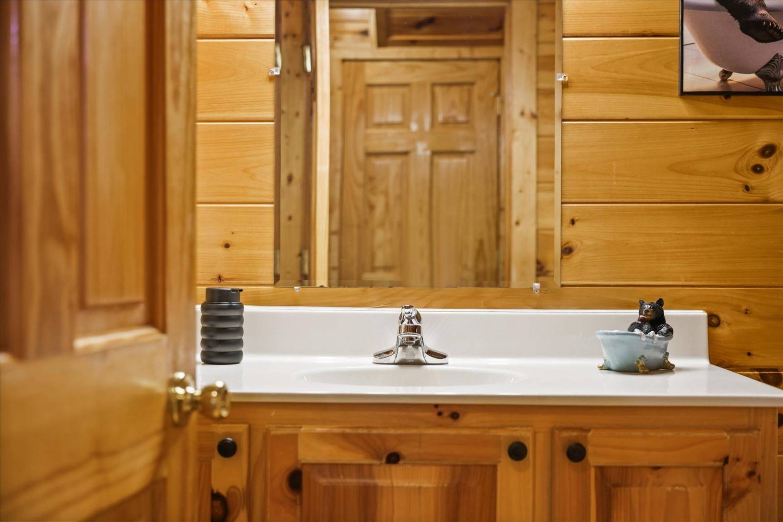 Wooden bathroom vanity with white sink, chrome faucet, and mirror