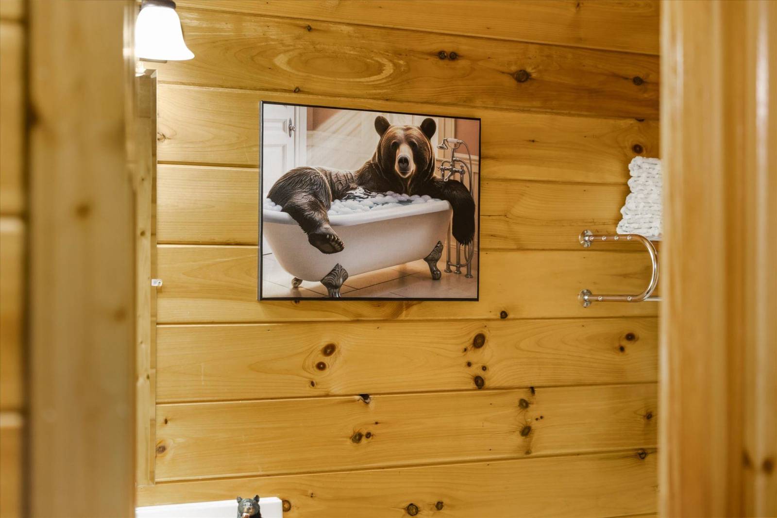 Framed print of a bear in a bubble bath on a wood-paneled wall