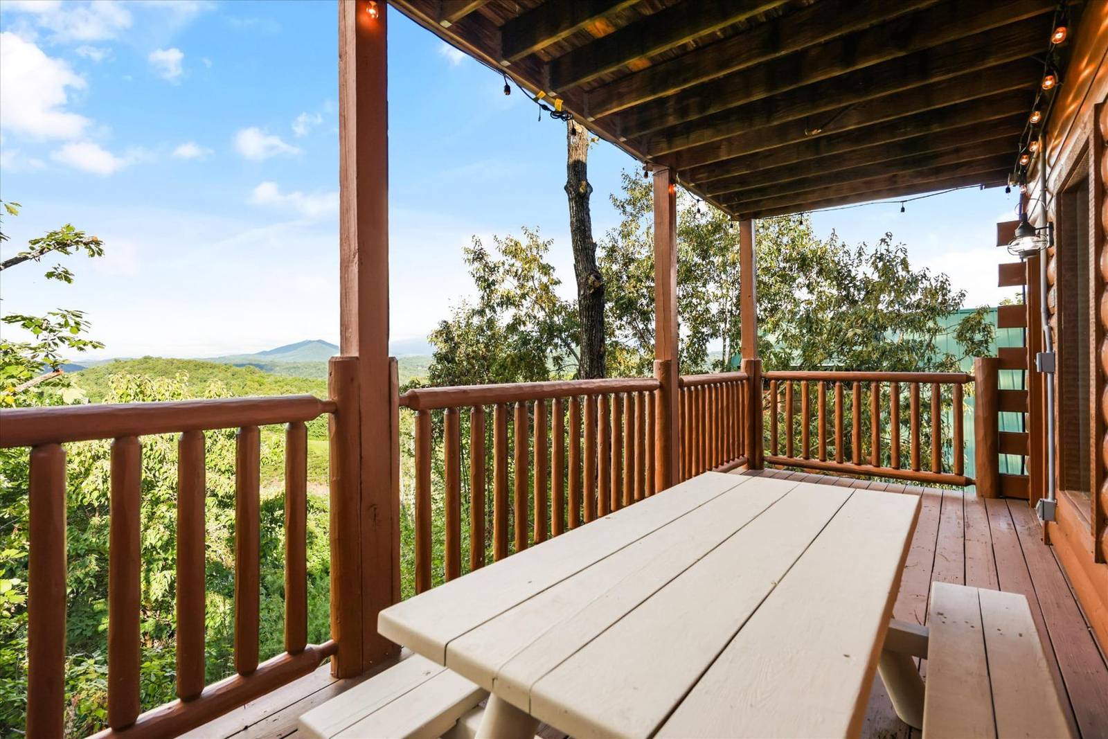 Wooden deck with white picnic table and mountain view