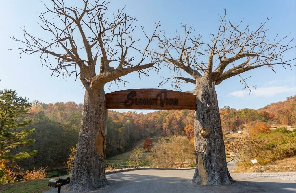 The carved tree arch at the Summit View Resort entrance, with fall colors behind it